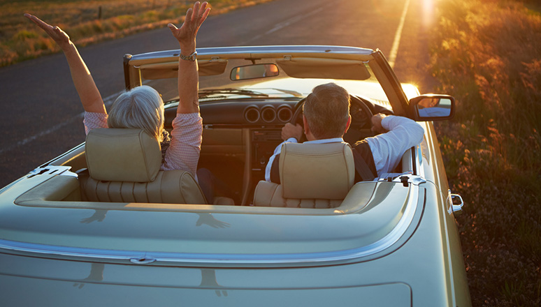 a couple driving in a car with the top down