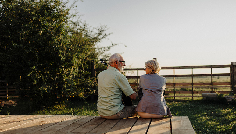 backview of old couple smiling on a porch