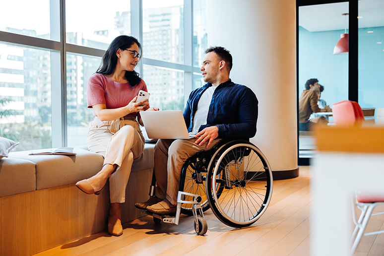 A man in a wheelchair and a woman chatting
