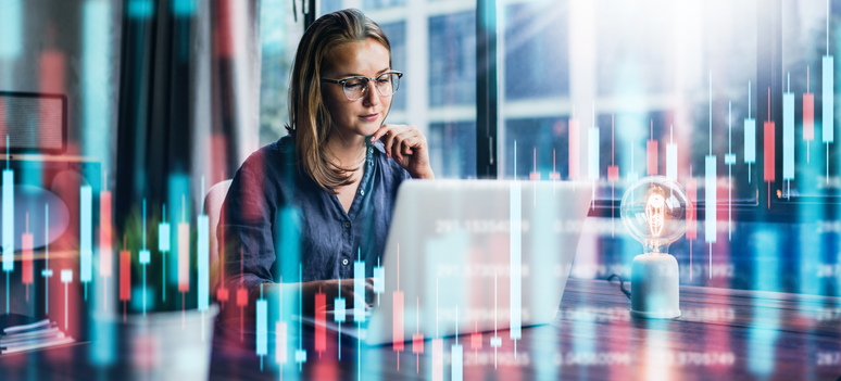 1286815175 Young woman working at modern office.Technical price graph and indicator, red and green candlestick chart and stock trading computer screen background. Double exposure. Trader analyzing data