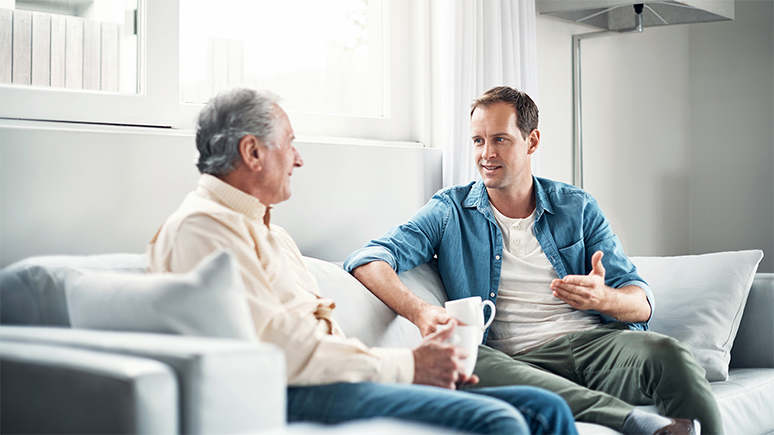 a man and his dad sitting on a couch and talking