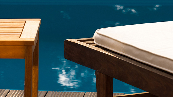 Chaise longue in a tropical swimming pool