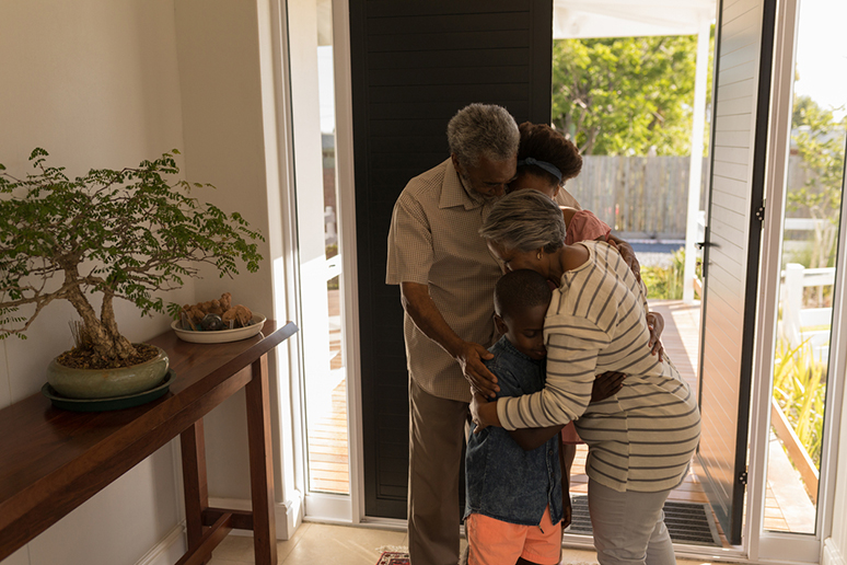 a family hugging by the doorway