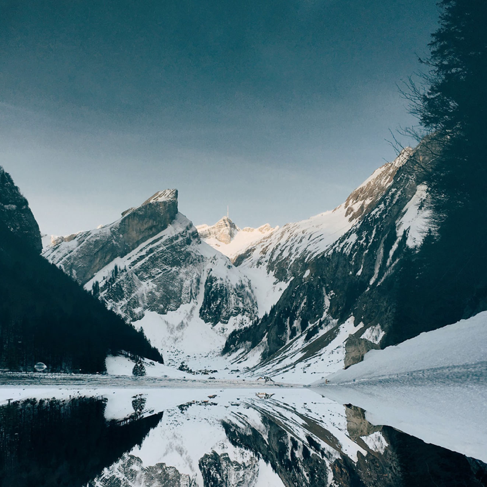 Snow-covered mountain near lake under blue sky